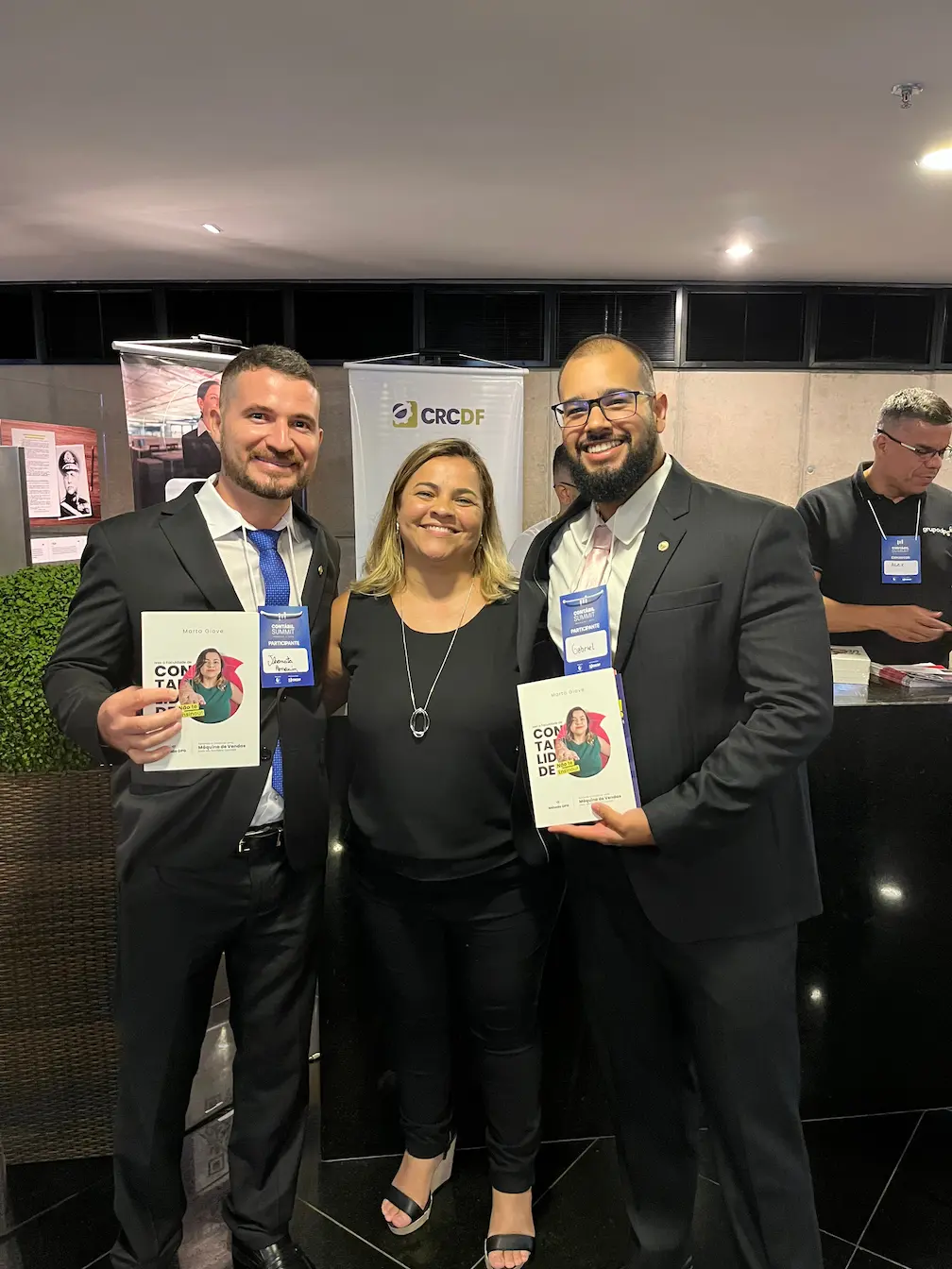 Marta Giove com dois leitores segurando o livro